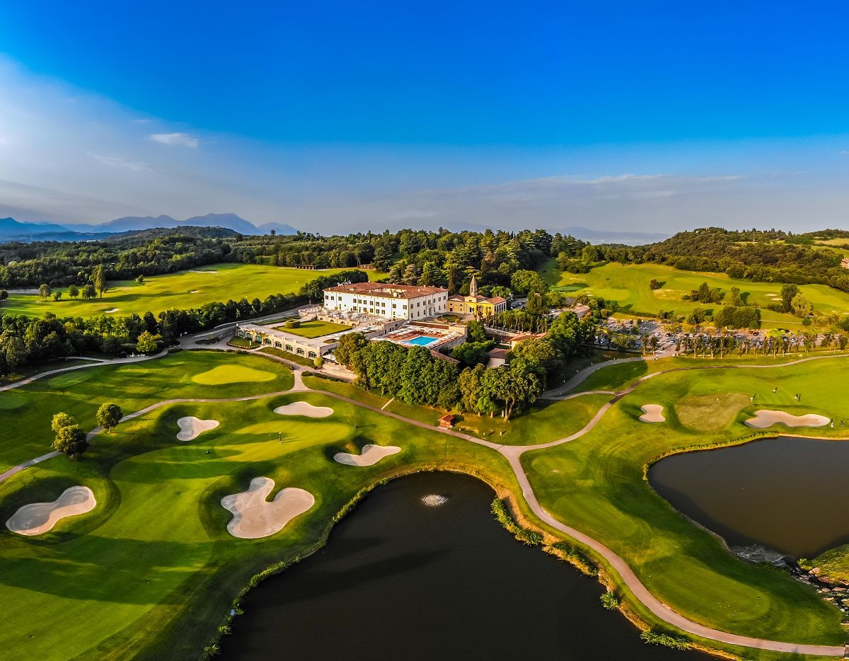 Veduta aerea dell'Arzaga Golf Club: la club house nella tenuta storica, il percorso e i laghetti